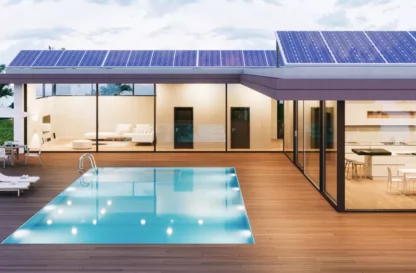 Maison avec de grandes baies vitrées ainsi qu'une piscine extérieure entourée d'une terrasse en bois.