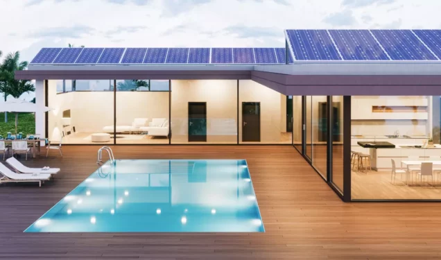 Maison avec de grandes baies vitrées ainsi qu'une piscine extérieure entourée d'une terrasse en bois.